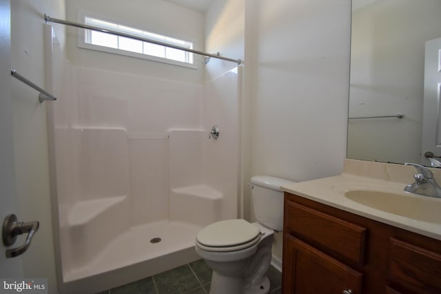 full bath with tile patterned flooring, toilet, vanity, and walk in shower