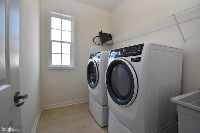 washroom featuring light tile patterned floors, baseboards, independent washer and dryer, and laundry area