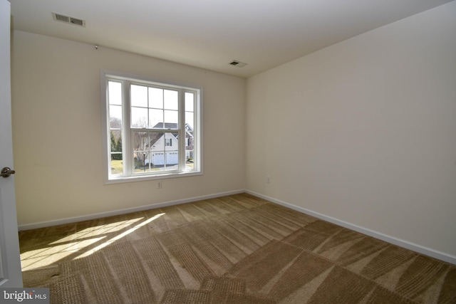 spare room with visible vents, baseboards, and carpet flooring