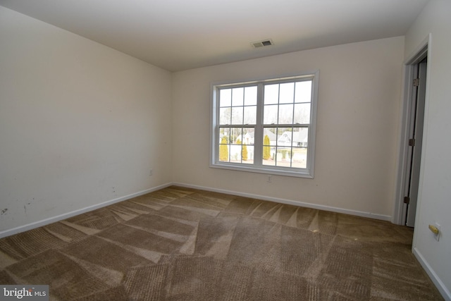 carpeted spare room with visible vents and baseboards