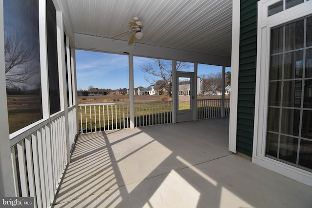 unfurnished sunroom featuring a ceiling fan