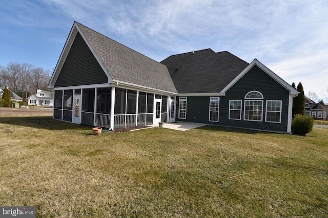 rear view of house featuring a lawn, a shingled roof, and a sunroom