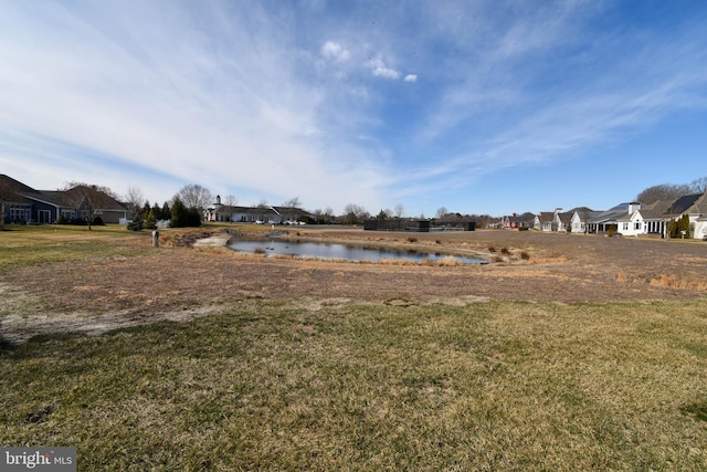 view of yard with a residential view and a water view