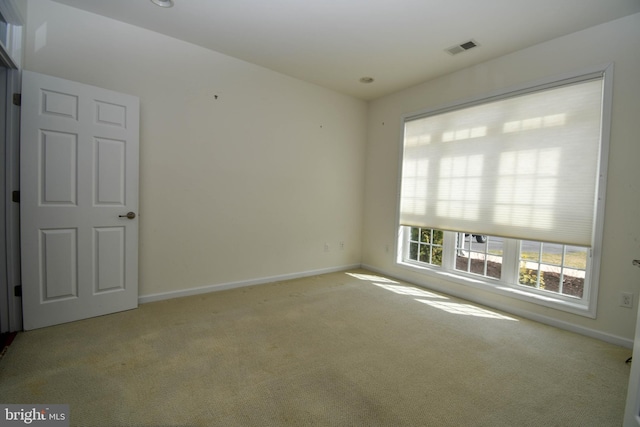 carpeted spare room with visible vents and baseboards