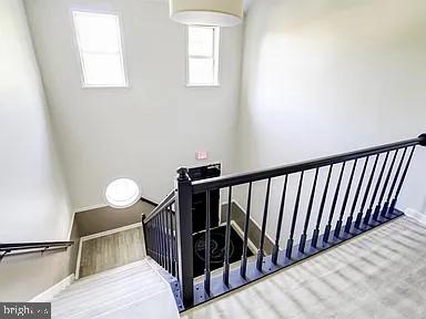 stairway with wood finished floors and baseboards