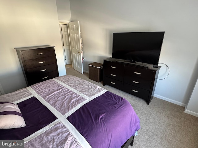 bedroom featuring light carpet and baseboards