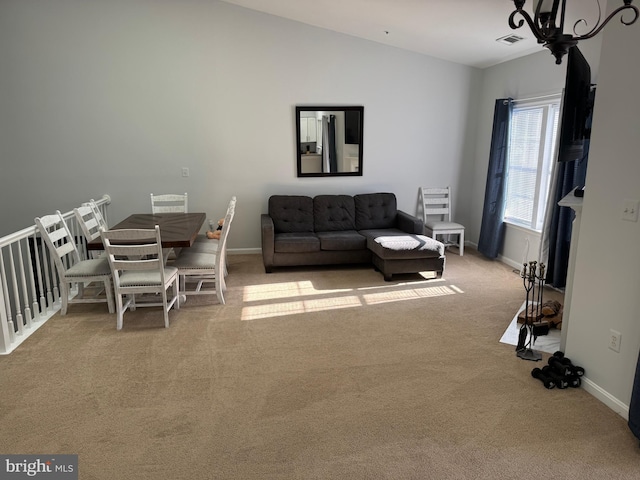 living area featuring light carpet, baseboards, visible vents, lofted ceiling, and an inviting chandelier