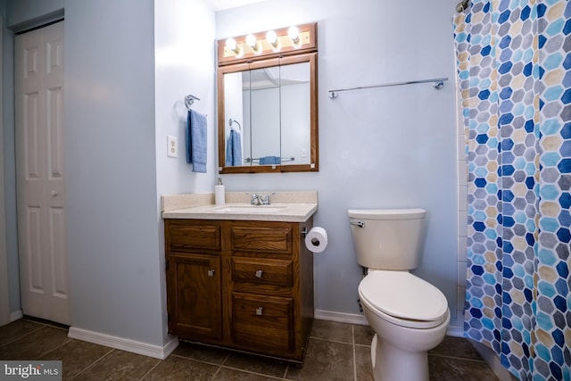 full bathroom with curtained shower, tile patterned flooring, toilet, vanity, and baseboards