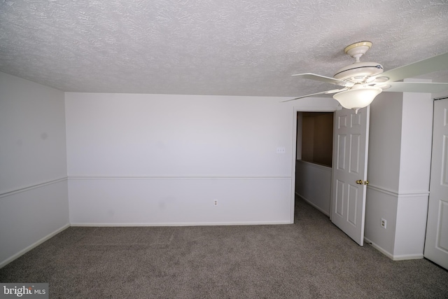 unfurnished room with a textured ceiling, carpet flooring, and baseboards