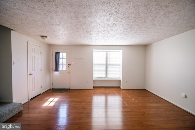 entrance foyer featuring a textured ceiling, wood finished floors, and baseboards