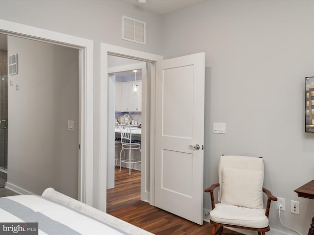 bedroom with dark wood-style floors and visible vents