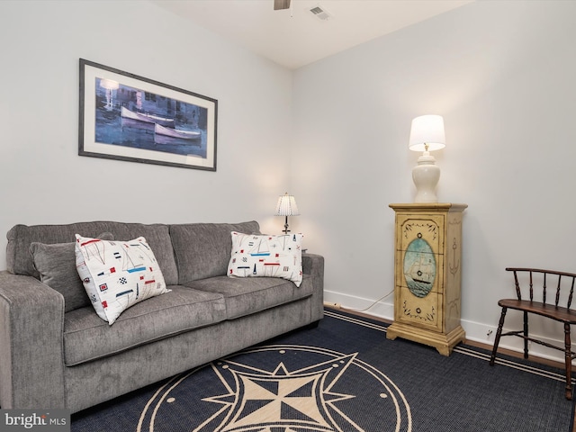 living room with carpet floors, baseboards, visible vents, and a ceiling fan