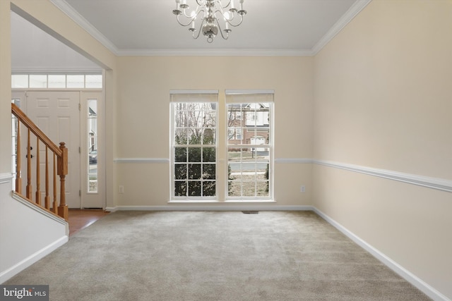 foyer with ornamental molding, an inviting chandelier, a wealth of natural light, and light colored carpet