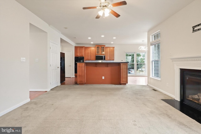 unfurnished living room with recessed lighting, a fireplace with flush hearth, baseboards, and light colored carpet