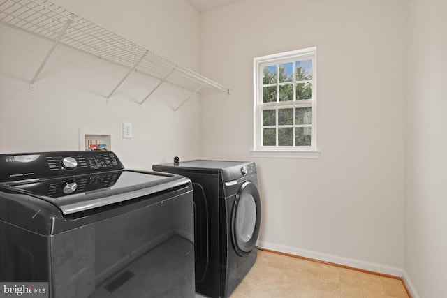 laundry room with laundry area, baseboards, and washing machine and clothes dryer