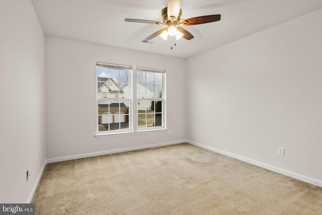 spare room featuring baseboards, visible vents, a ceiling fan, and light colored carpet