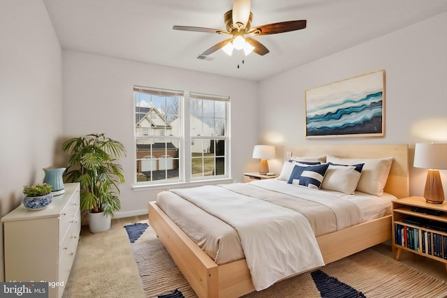 bedroom featuring baseboards, a ceiling fan, visible vents, and light colored carpet