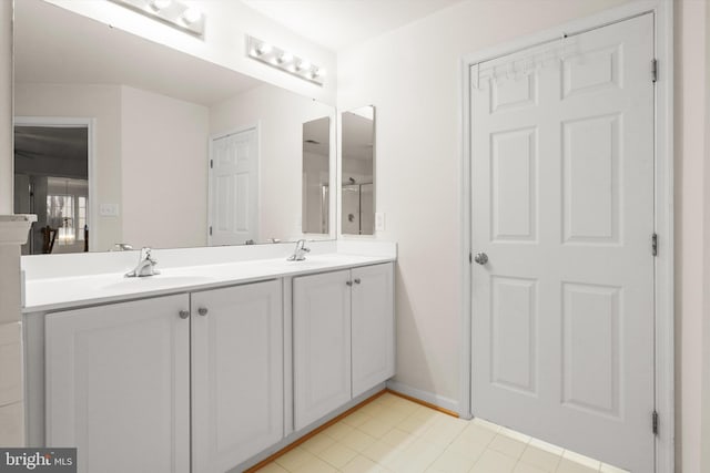 bathroom with double vanity, a sink, and baseboards