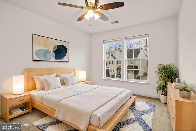 bedroom with light carpet, a ceiling fan, visible vents, and baseboards