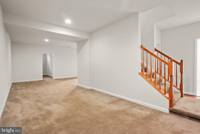 empty room with light carpet, stairs, baseboards, and recessed lighting