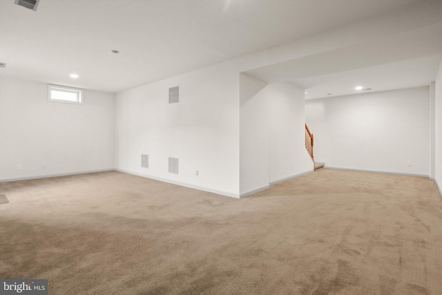 below grade area featuring carpet floors, stairway, visible vents, and recessed lighting