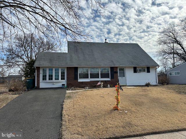 view of front of home with driveway, a front lawn, and brick siding