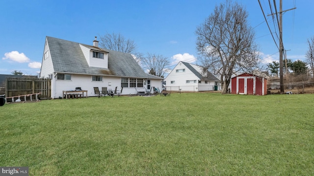 rear view of property with an outbuilding, a fenced backyard, a lawn, and a storage shed