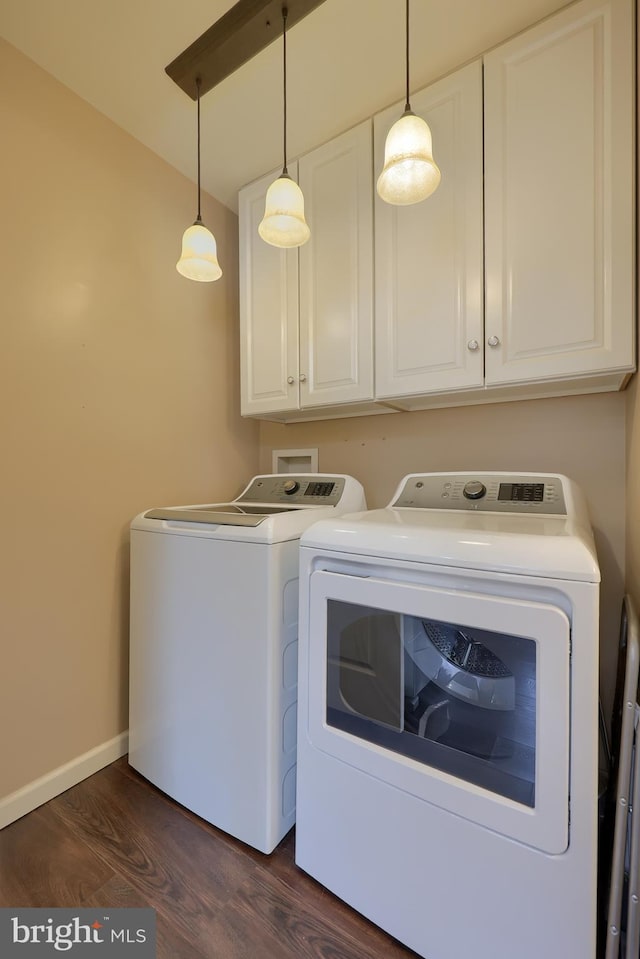 laundry room featuring cabinet space, baseboards, dark wood-style floors, and washer and clothes dryer