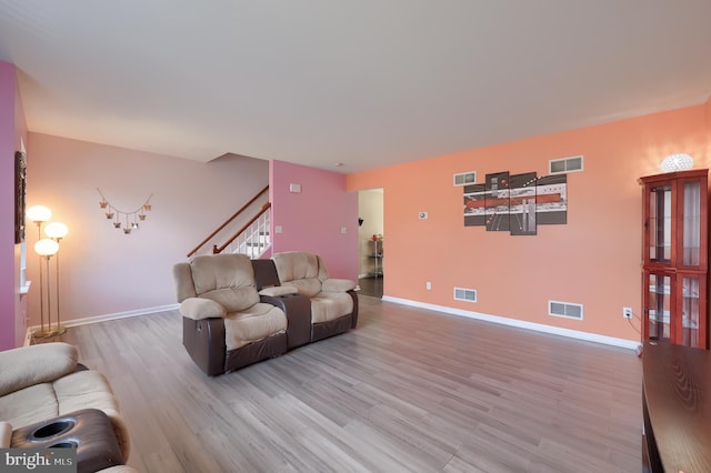 living area featuring light wood-style flooring and visible vents