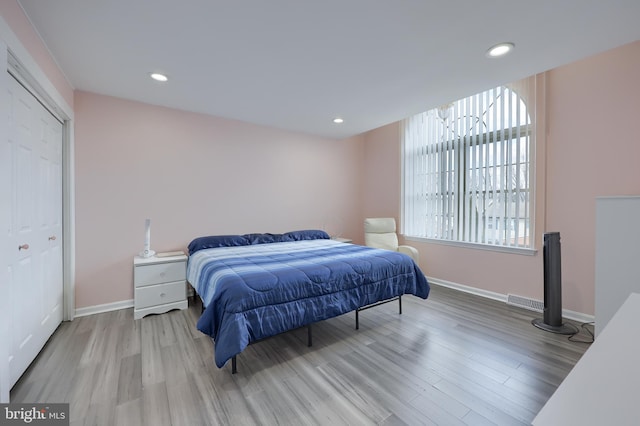 bedroom with baseboards, wood finished floors, and recessed lighting