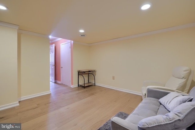 living area featuring light wood-type flooring, baseboards, ornamental molding, and recessed lighting