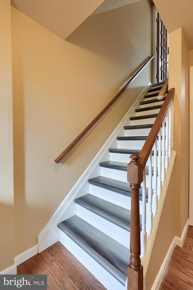 stairs featuring baseboards and wood finished floors