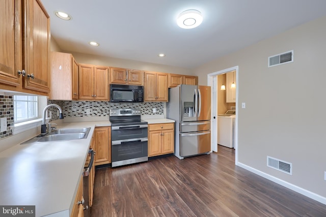 kitchen with visible vents, appliances with stainless steel finishes, washer / clothes dryer, and a sink