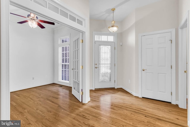 entrance foyer featuring light wood-style flooring, a ceiling fan, and baseboards