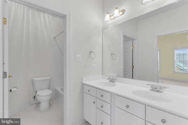 bathroom featuring a sink, washtub / shower combination, toilet, and double vanity