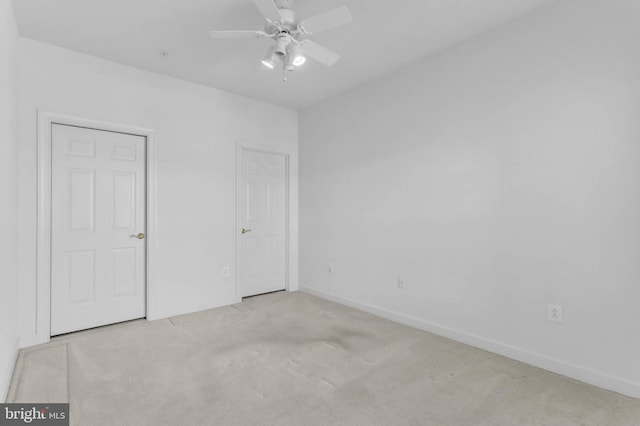 unfurnished bedroom with a ceiling fan, carpet, and baseboards