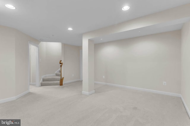 finished below grade area with light carpet, recessed lighting, stairs, and baseboards