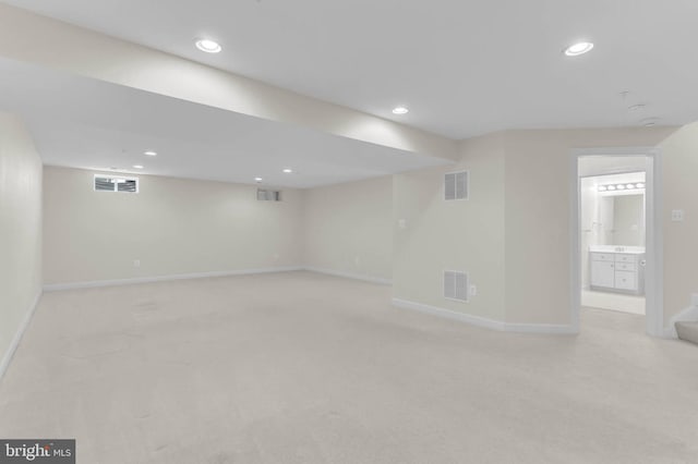 finished basement with recessed lighting, visible vents, and light carpet