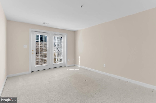 carpeted empty room with visible vents and baseboards