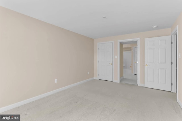 unfurnished bedroom featuring baseboards and light carpet