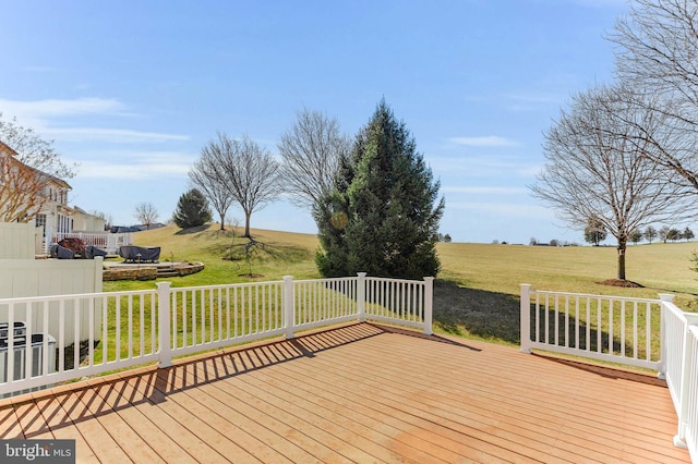 wooden deck featuring a rural view and a lawn