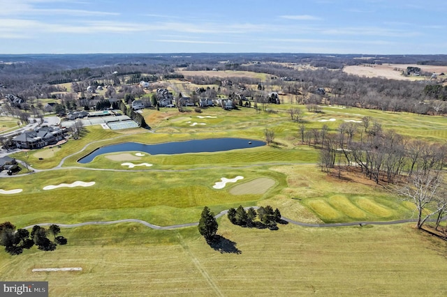 aerial view with golf course view and a water view