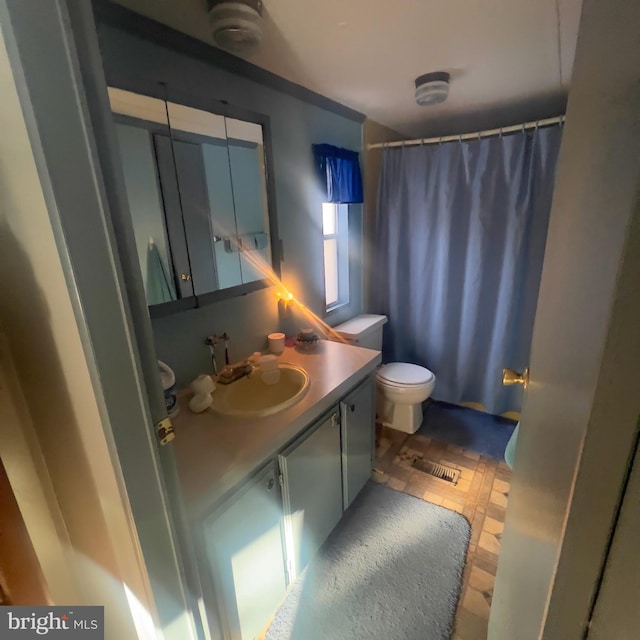 full bathroom featuring a shower with shower curtain, visible vents, vanity, and toilet