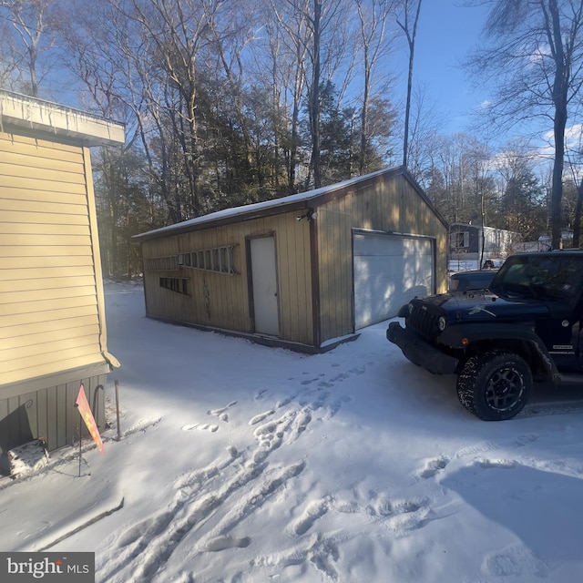 snow covered garage with a garage