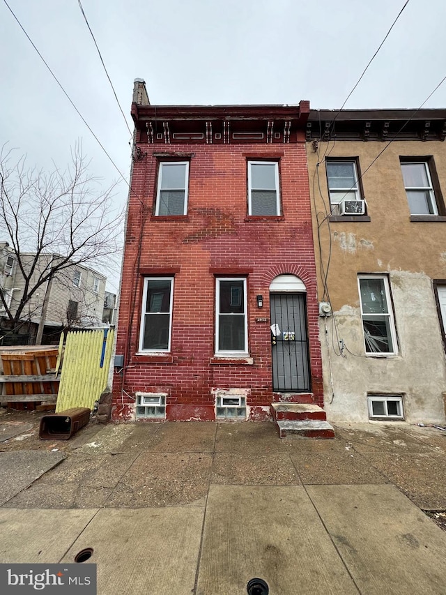 view of front of property featuring fence, brick siding, and entry steps