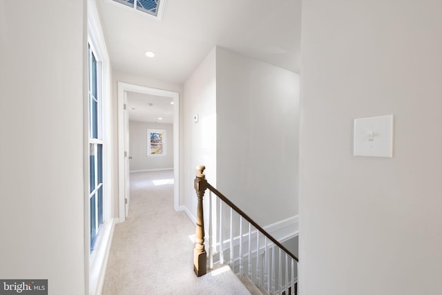 corridor featuring light colored carpet, recessed lighting, visible vents, an upstairs landing, and baseboards