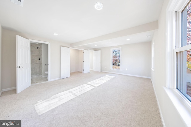 unfurnished bedroom featuring light colored carpet, recessed lighting, ensuite bath, visible vents, and baseboards