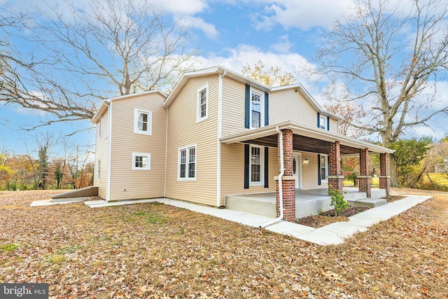 view of side of home featuring covered porch