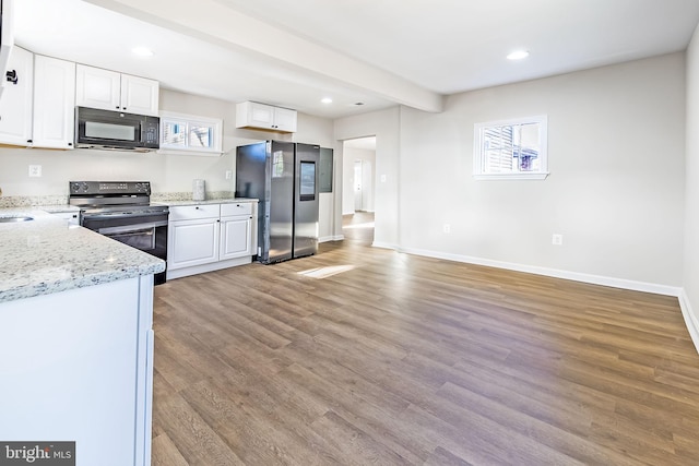 kitchen with white cabinetry, light wood-style flooring, black appliances, and light stone counters