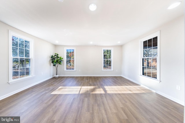 unfurnished room featuring baseboards, recessed lighting, and wood finished floors